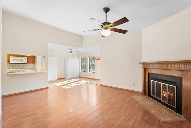 unfurnished living room featuring ceiling fan, light hardwood / wood-style flooring, and lofted ceiling