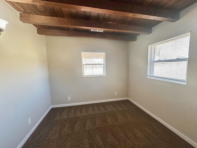 unfurnished room with dark colored carpet, beam ceiling, and wooden ceiling