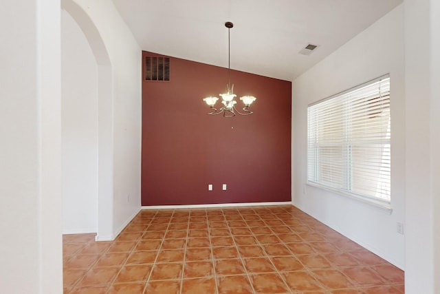 tiled spare room with a wealth of natural light, lofted ceiling, and a notable chandelier