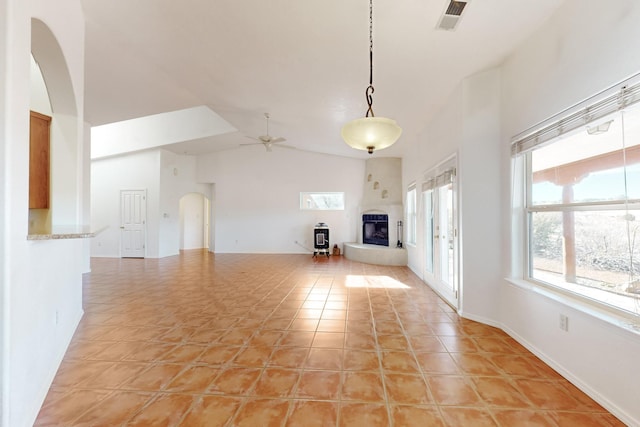 unfurnished living room with ceiling fan, light tile patterned floors, and high vaulted ceiling