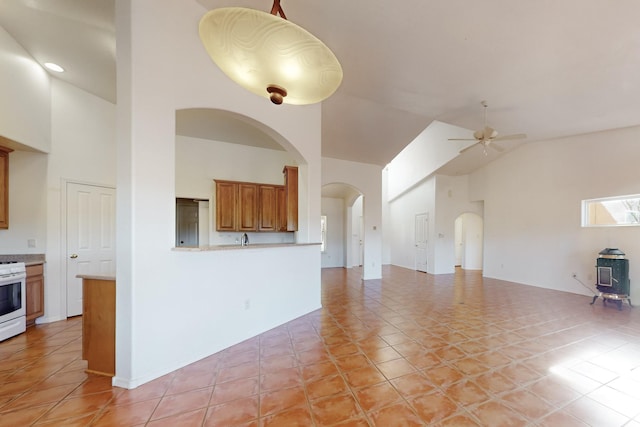 unfurnished living room featuring high vaulted ceiling, ceiling fan, and light tile patterned flooring