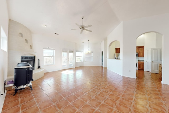 living room with ceiling fan, lofted ceiling, and light tile patterned flooring