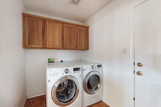 laundry area featuring cabinets, independent washer and dryer, and tile patterned floors