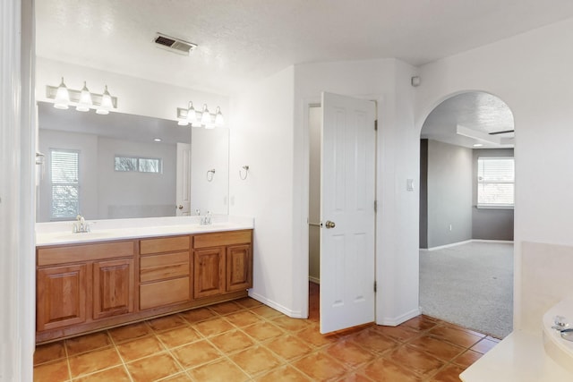 bathroom with tile patterned floors, vanity, and a textured ceiling