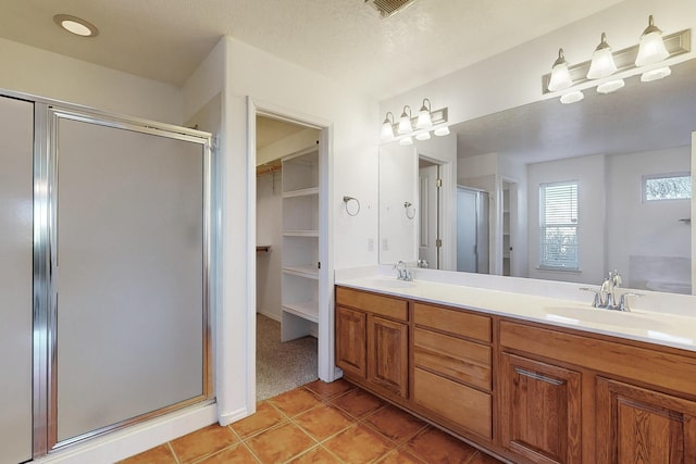 bathroom featuring tile patterned flooring, shower with separate bathtub, vanity, and a textured ceiling