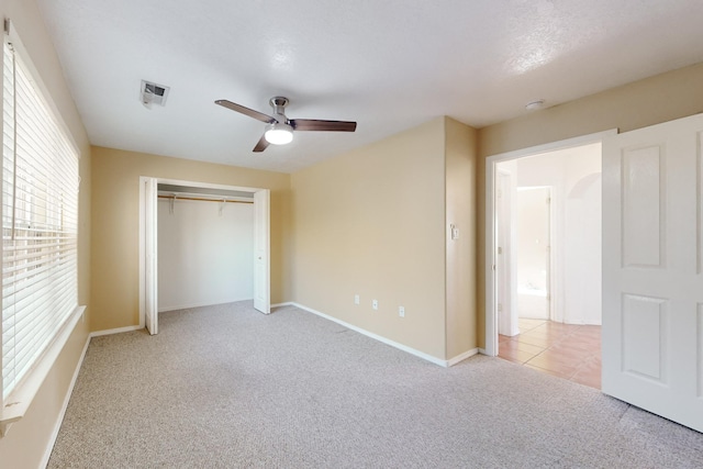 unfurnished bedroom with ceiling fan, a closet, and light colored carpet