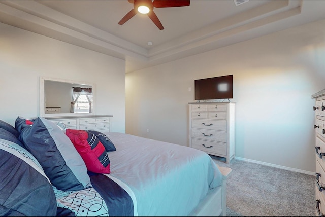 bedroom with a tray ceiling, ceiling fan, and light colored carpet