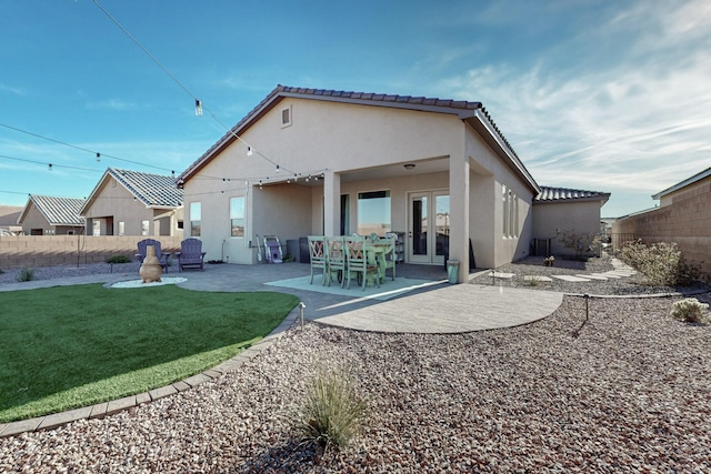 rear view of house featuring a yard, a patio, and french doors