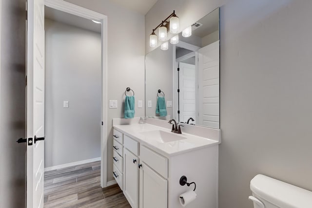 bathroom featuring hardwood / wood-style flooring, vanity, and toilet