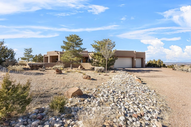 pueblo-style house featuring a garage