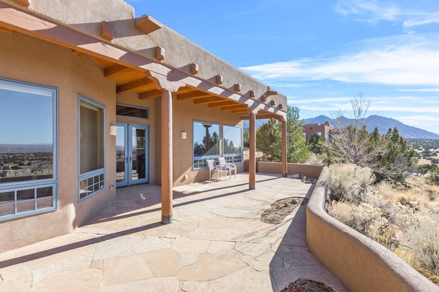 view of patio with a mountain view and french doors