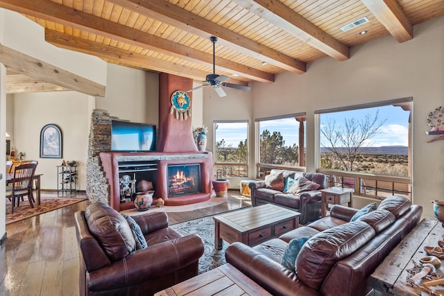 living room featuring wooden ceiling, ceiling fan, a fireplace, beam ceiling, and wood-type flooring