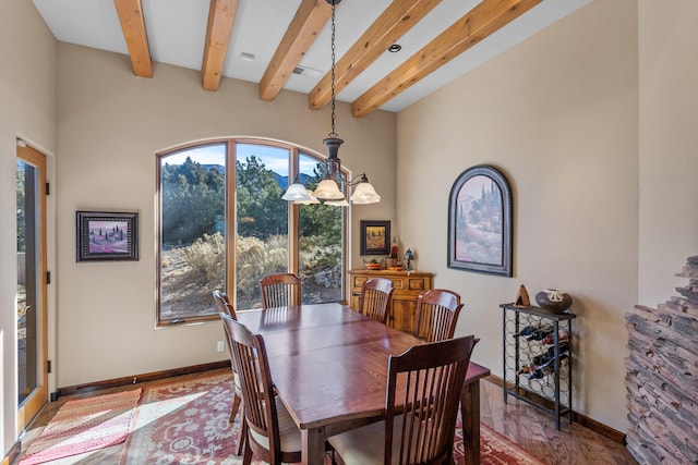 dining area featuring beam ceiling, an inviting chandelier, and hardwood / wood-style floors