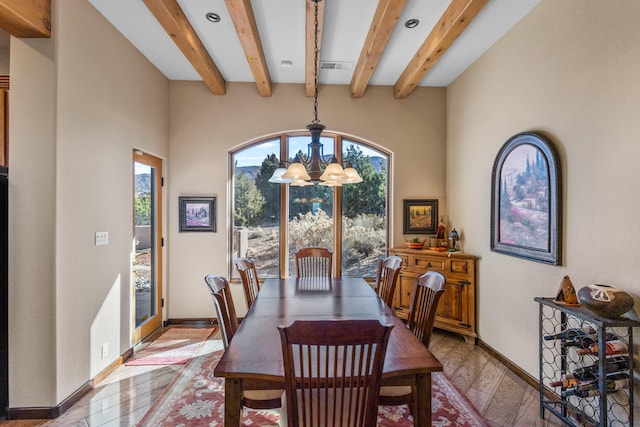 dining space featuring a notable chandelier, light hardwood / wood-style floors, and beam ceiling