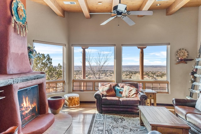 sunroom / solarium with beam ceiling, ceiling fan, and wooden ceiling