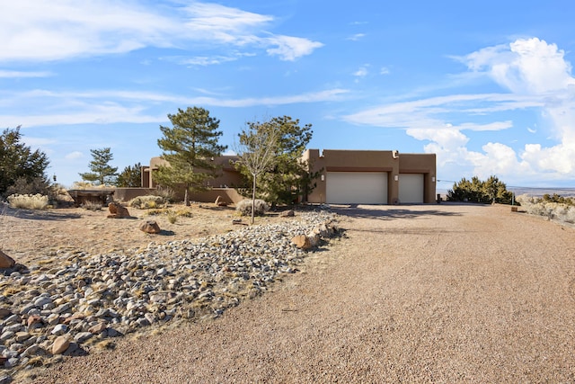 pueblo-style home featuring a garage