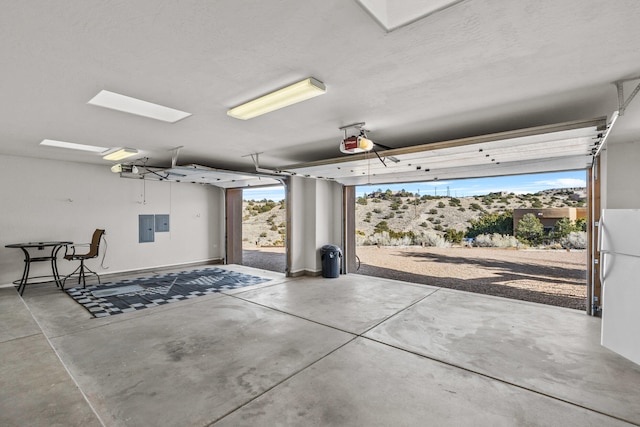 garage with electric panel, white fridge, and a garage door opener