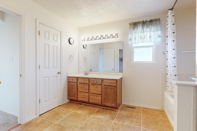 bathroom featuring shower / bath combo with shower curtain, vanity, and a textured ceiling