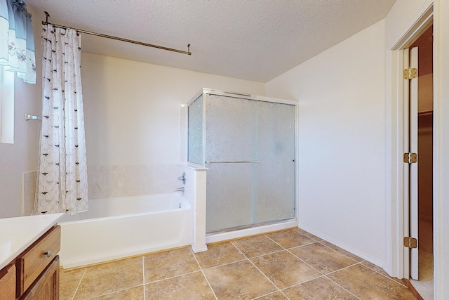 bathroom with vanity, plus walk in shower, and a textured ceiling