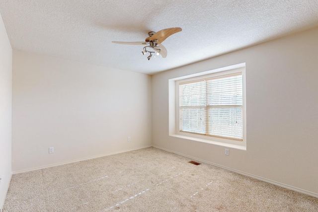 unfurnished room featuring a textured ceiling, ceiling fan, and light carpet