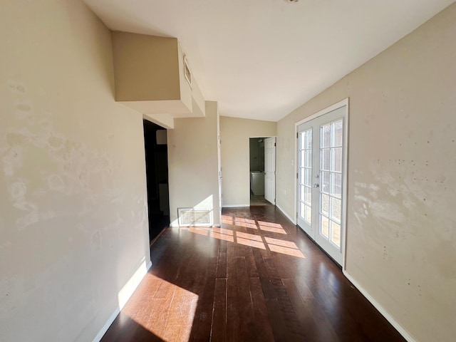 spare room with dark wood-type flooring and french doors