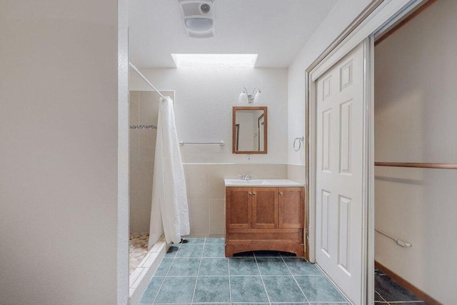 bathroom with tile patterned flooring, a shower with curtain, and vanity