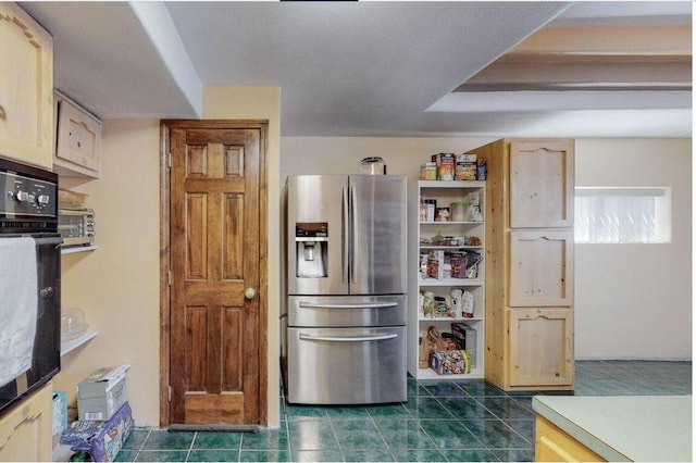 kitchen with stainless steel fridge with ice dispenser, light brown cabinetry, and oven