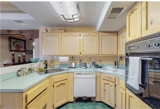 kitchen with dishwasher, light brown cabinets, sink, cooktop, and oven