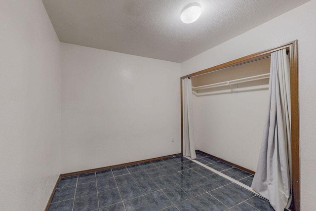 unfurnished bedroom with a textured ceiling and a closet