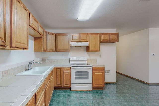 kitchen with electric range, tile countertops, sink, and a textured ceiling