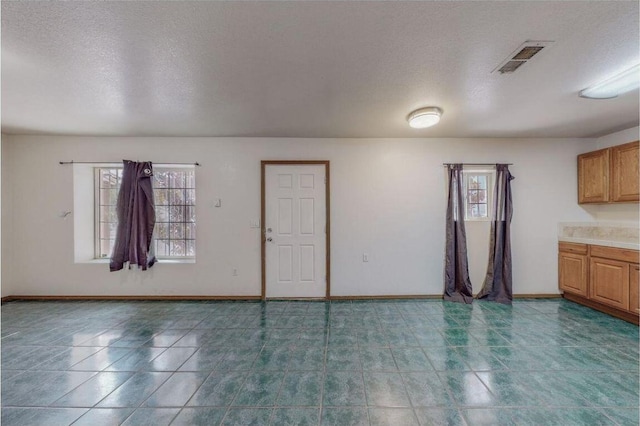 interior space featuring a healthy amount of sunlight and a textured ceiling