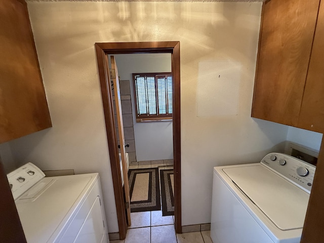 laundry area with cabinet space, independent washer and dryer, and light tile patterned flooring