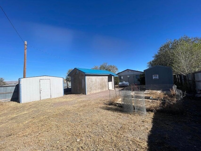 exterior space featuring an outbuilding, a storage shed, and fence