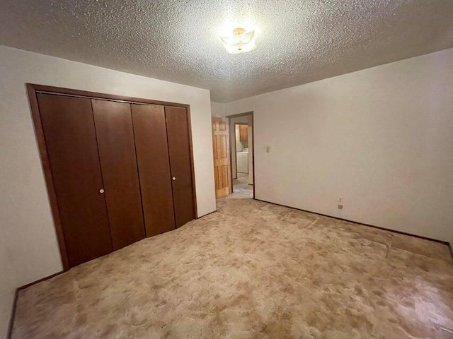 unfurnished bedroom featuring a closet, light colored carpet, and a textured ceiling