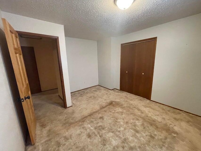 unfurnished bedroom with carpet flooring, a closet, and a textured ceiling