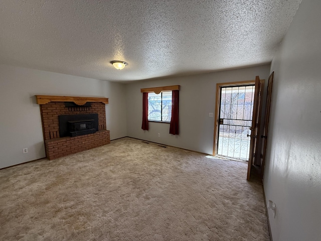 unfurnished living room with a fireplace, carpet floors, and a textured ceiling