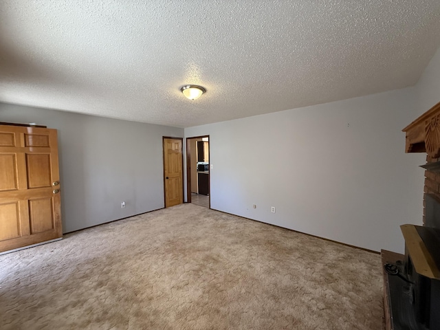 interior space featuring light colored carpet, a fireplace, and a textured ceiling