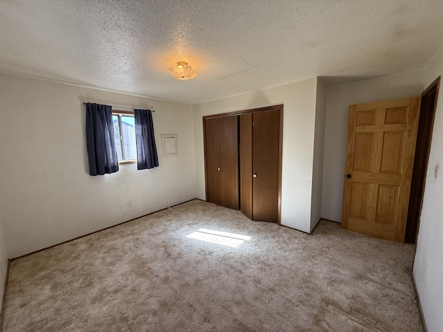 unfurnished bedroom with a closet, carpet flooring, and a textured ceiling