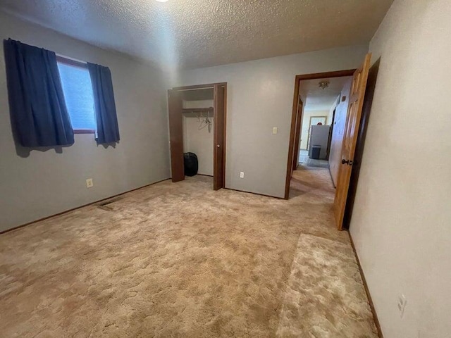 unfurnished bedroom with a closet, a textured ceiling, and carpet floors