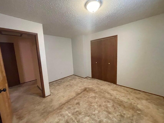 unfurnished bedroom featuring a closet, a textured ceiling, and carpet floors