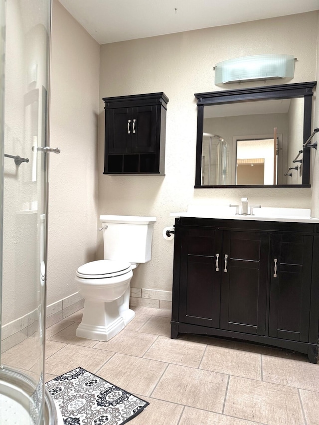 bathroom with toilet, vanity, and walk in shower