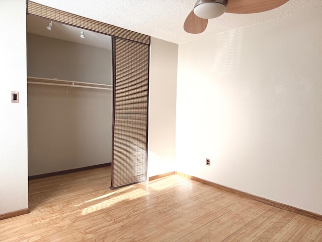 unfurnished bedroom with light wood-type flooring, a textured ceiling, a closet, and ceiling fan