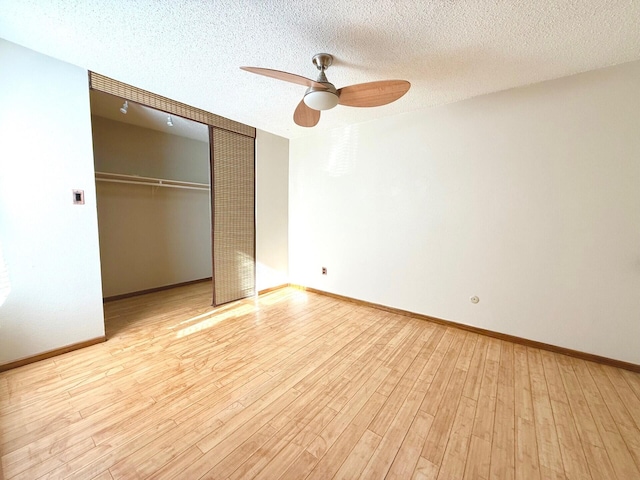 unfurnished bedroom with ceiling fan, a closet, light hardwood / wood-style floors, and a textured ceiling