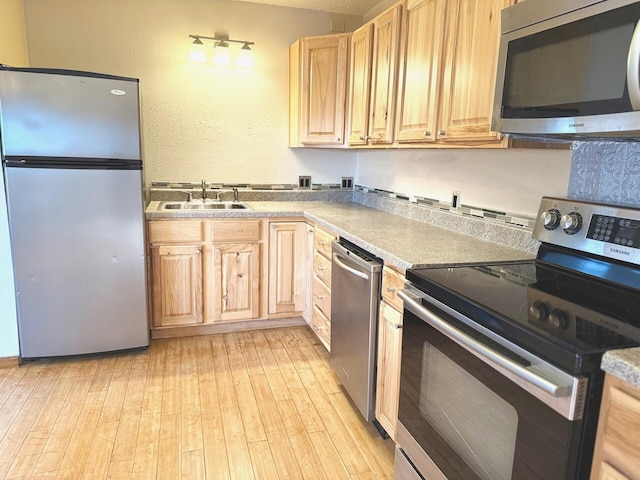 kitchen featuring sink, light hardwood / wood-style flooring, light brown cabinets, and appliances with stainless steel finishes