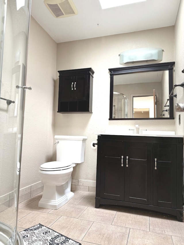 bathroom with an enclosed shower, vanity, and toilet