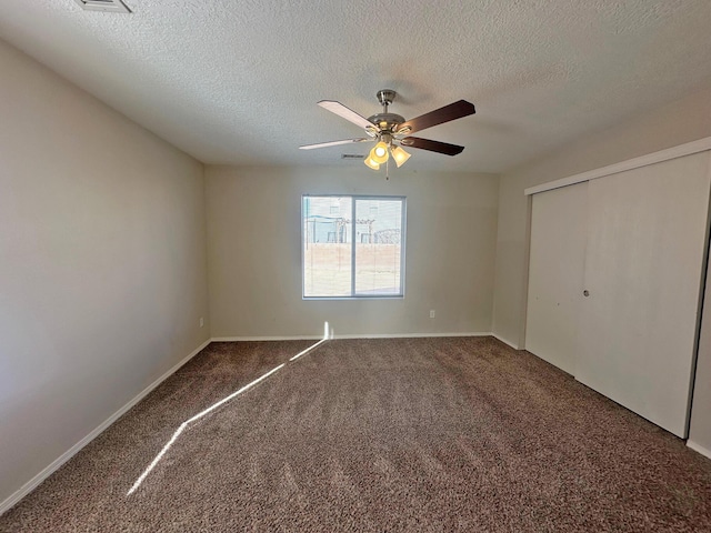 unfurnished bedroom featuring a closet, a textured ceiling, ceiling fan, and carpet flooring