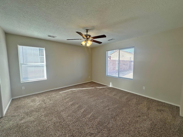 carpeted empty room featuring a textured ceiling and ceiling fan