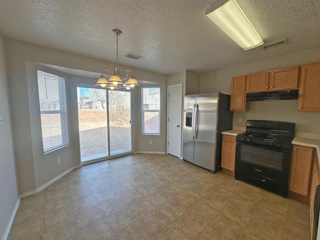 kitchen featuring decorative light fixtures, a chandelier, black range with gas cooktop, and stainless steel fridge