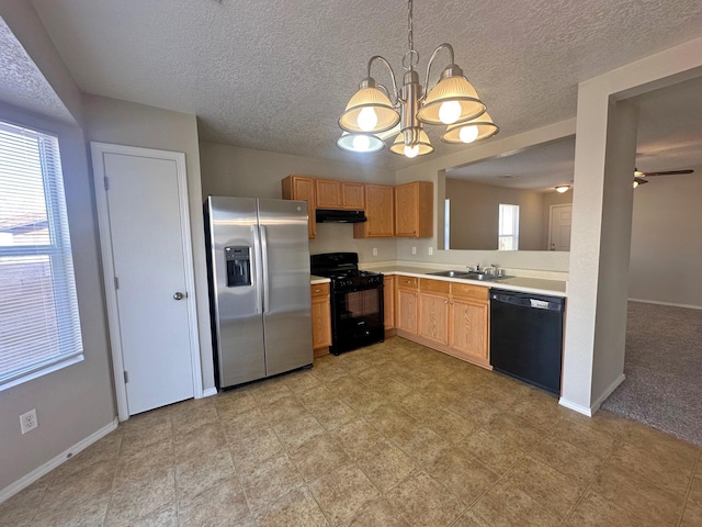 kitchen featuring a wealth of natural light, decorative light fixtures, black appliances, ceiling fan with notable chandelier, and sink