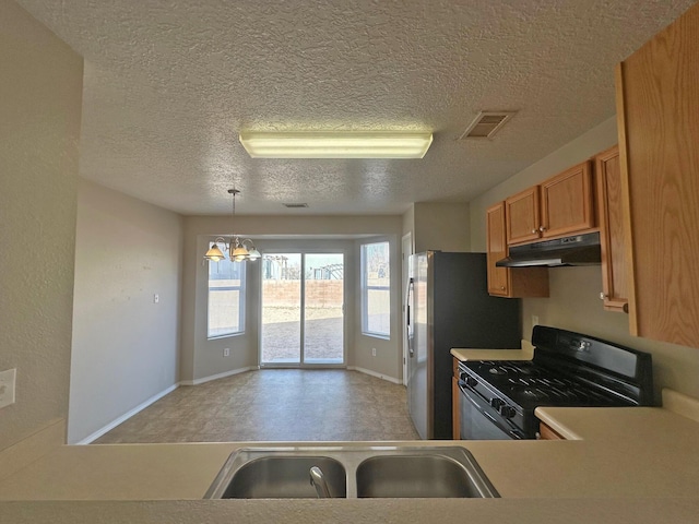 kitchen with hanging light fixtures, stainless steel refrigerator with ice dispenser, an inviting chandelier, black range with gas stovetop, and sink